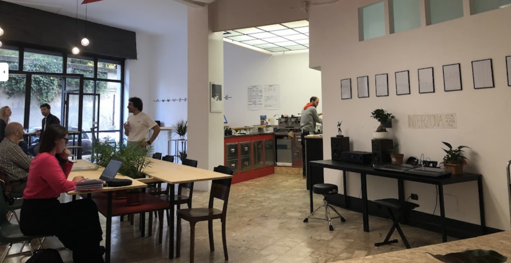 Interior photo of Ammazza Caffe showing several people working on laptops and drinking coffee