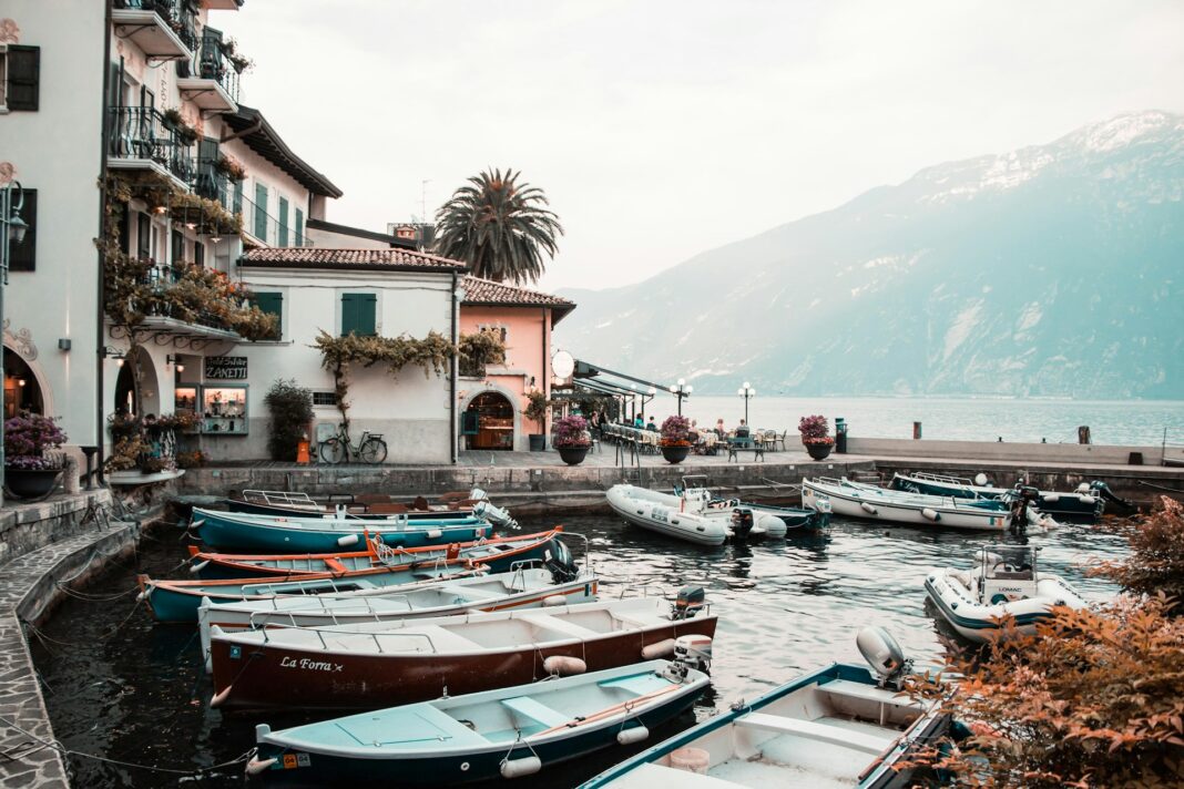 small boats sit in the water at a dock on Lake Garda in italy