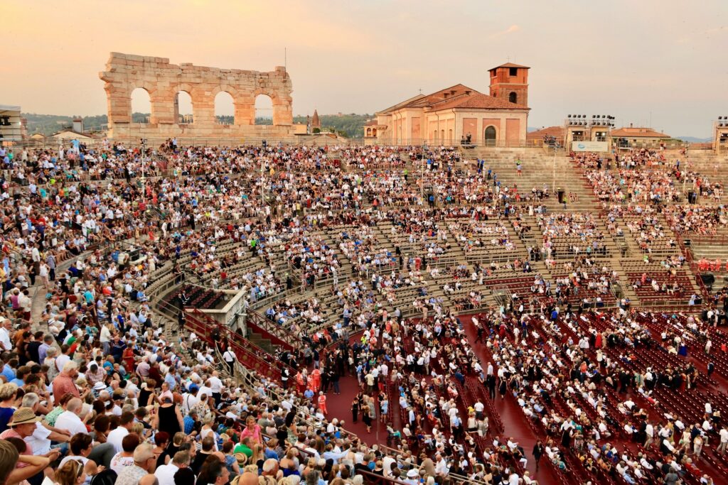 a crowd of people gets ready to see an opera at the Verona Arena