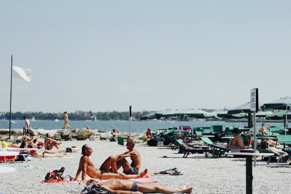 sunbathers lay out on the beach in Lake Garda