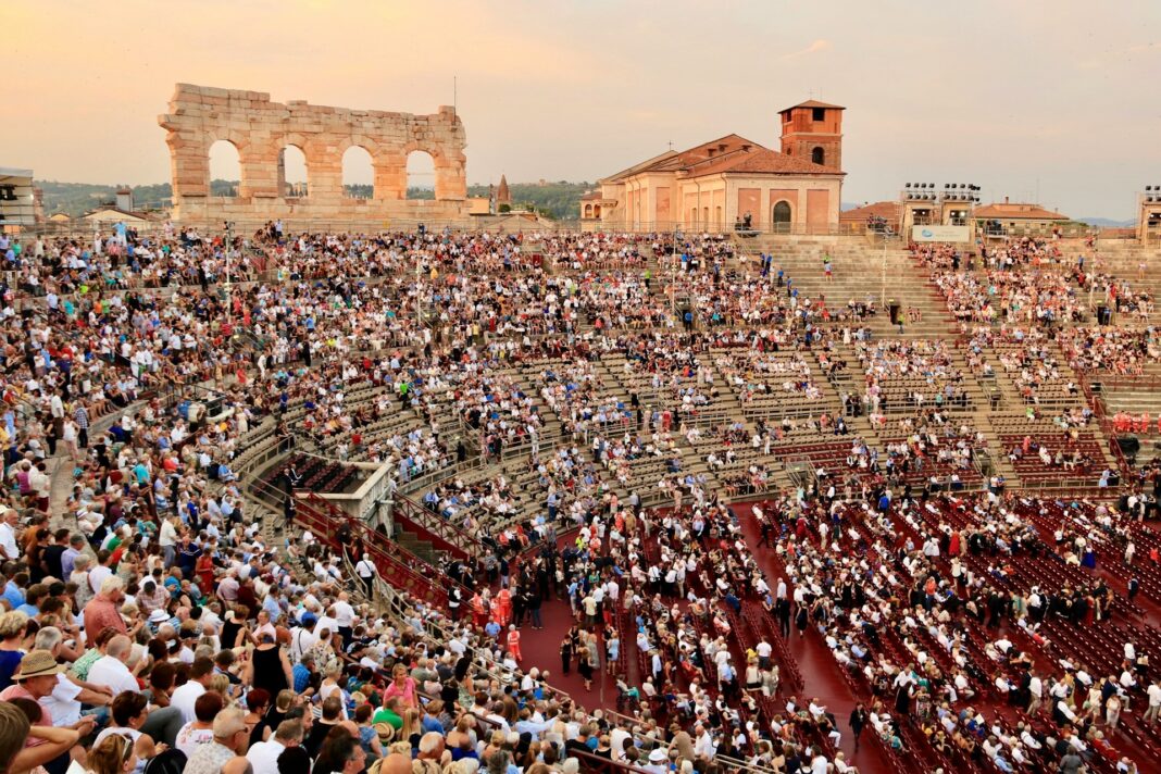 Verona Opera Festival attendees sit in the Verona Arena as the sun goes down